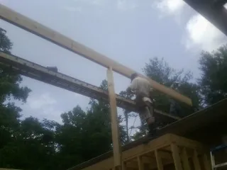 Carpenter setting a ridge beam over a new addition frame — Ice Dam Removal by Roofing Brothers in Florahome