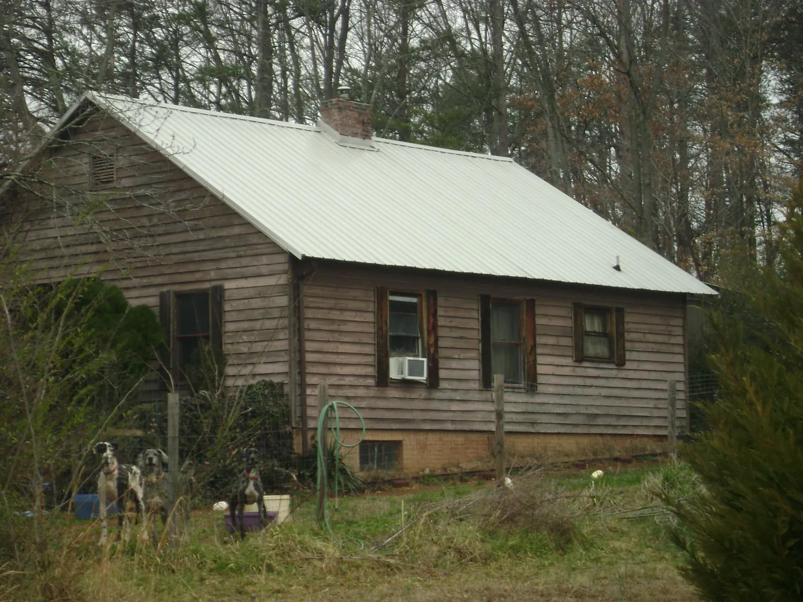 White metal roof on an old wood sided farmhouse, from a Metal Roof Installation job in Florahome